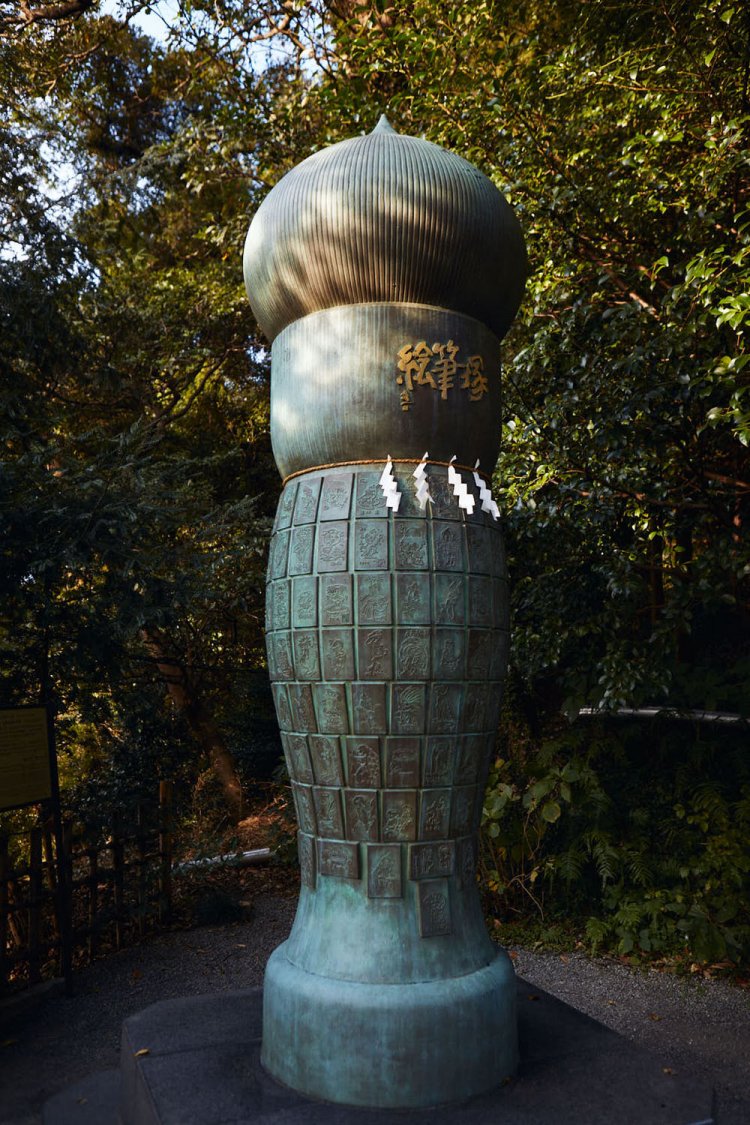 漫画家作製のレリーフがはまる絵筆塚。