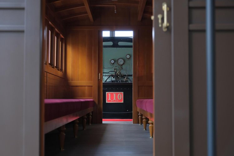 中等クラスの客車から110形をみる。通勤電車のようにお見合いタイプのロングシートであった。