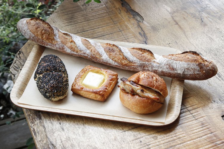 16時間かけてゆっくり発酵させるバゲットは、皮はパリパリ、中はもちもち。国産小麦のバゲット290円。塩あんぱん200円。クリームチーズデニッシュ220円。ダッチバンズ チキンステーキ310円。