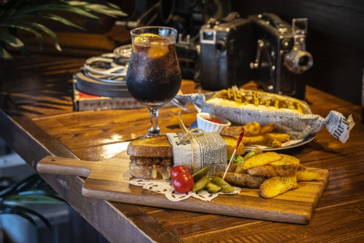 スロッピージョーベーコングリルチーズ、コニーアイランドホットドッグは、ポテト付きに変更も可。英国のキュリオスティ・コーラ。