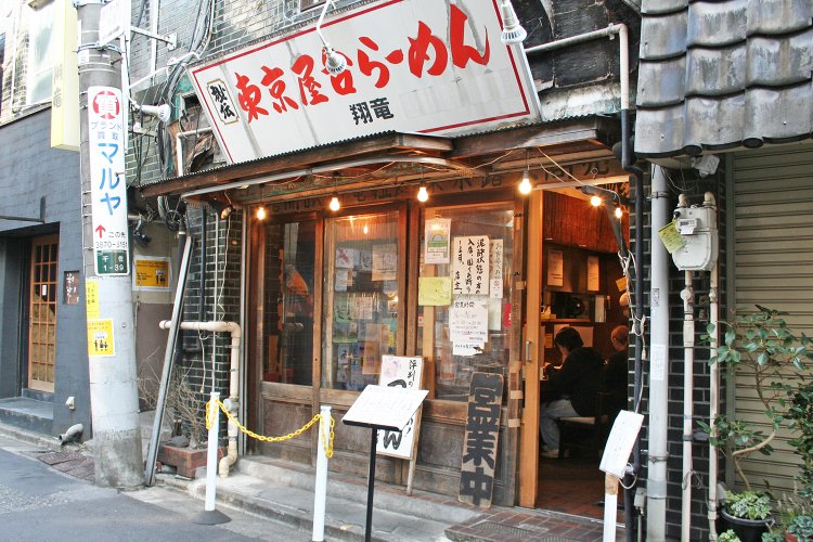 店頭のトタン屋根や裸電球が屋台時代をしのばせる。