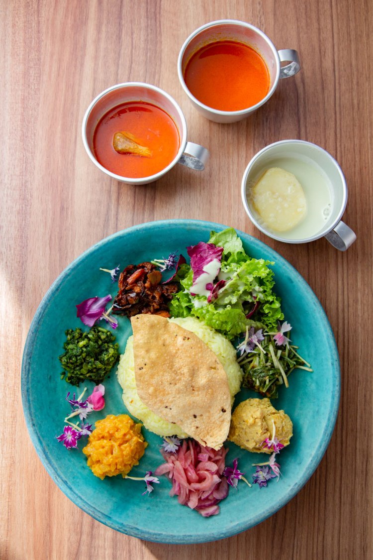 カンナスペシャルプレート1050円。ライスの上の豆のせんべい・ パパダンは砕いて食感をプラス。総菜は、赤タマネギのアチャールなどの6種に加え、サラダも添えられている。