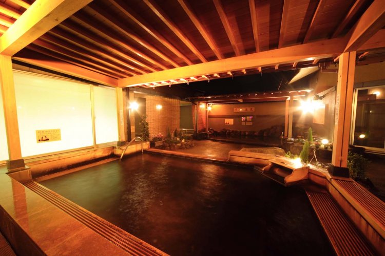 露天エリアのメイン浴槽となる桧風呂。腐植質温泉特有のモール臭が感じられる。