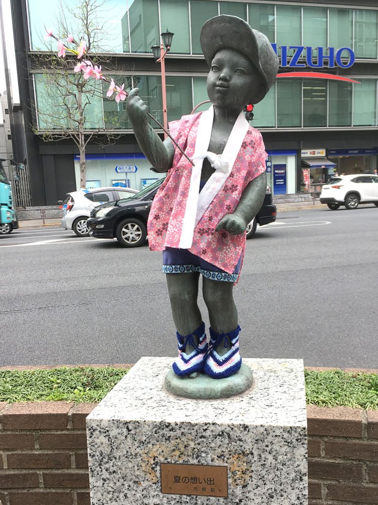 2019年4月撮影。桜模様のちゃんちゃんこを着て、桜の枝を持っているお花見仕様。