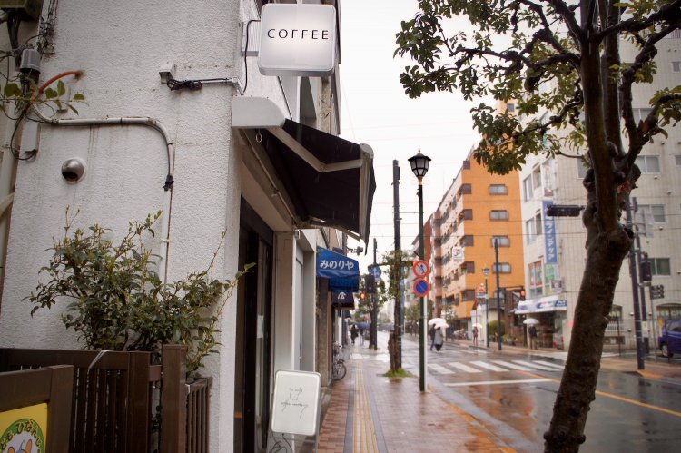 真っ白な一軒家の壁に、シンプルな「COFFEE」の文字が際立つ。