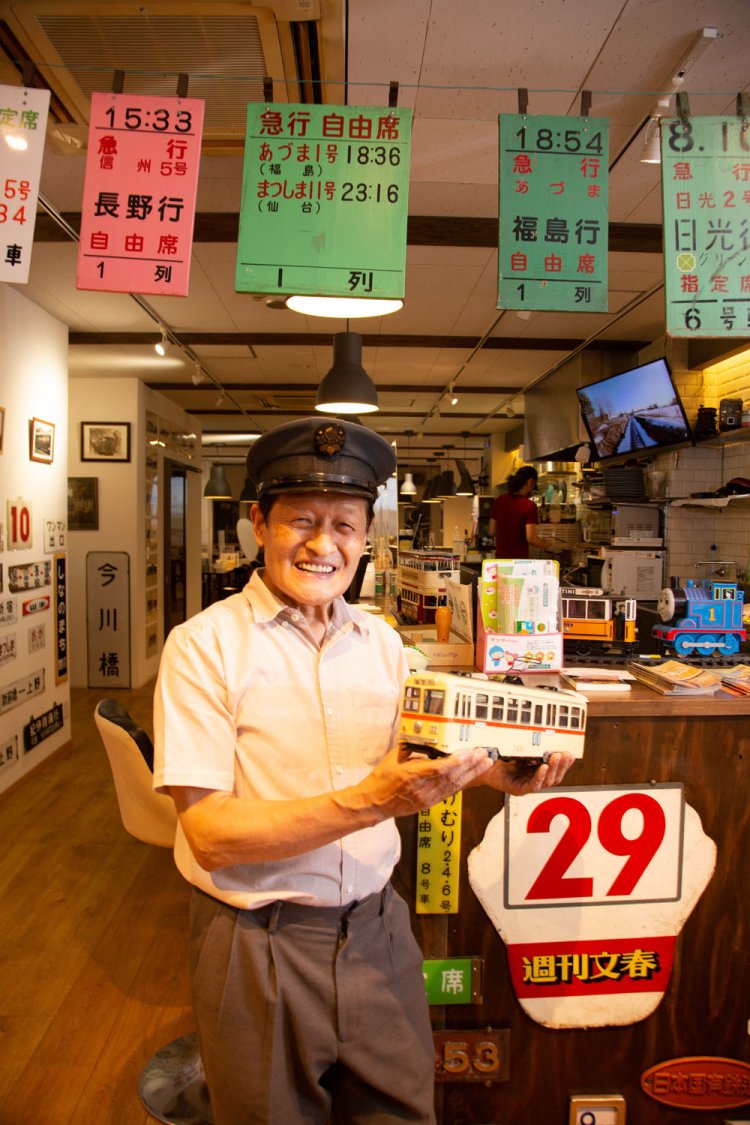 藤田さん。鉄道グッズ集めも趣味だが、一番好きなのは時刻表や車両の運行管理。店内には自身が書いた本も！