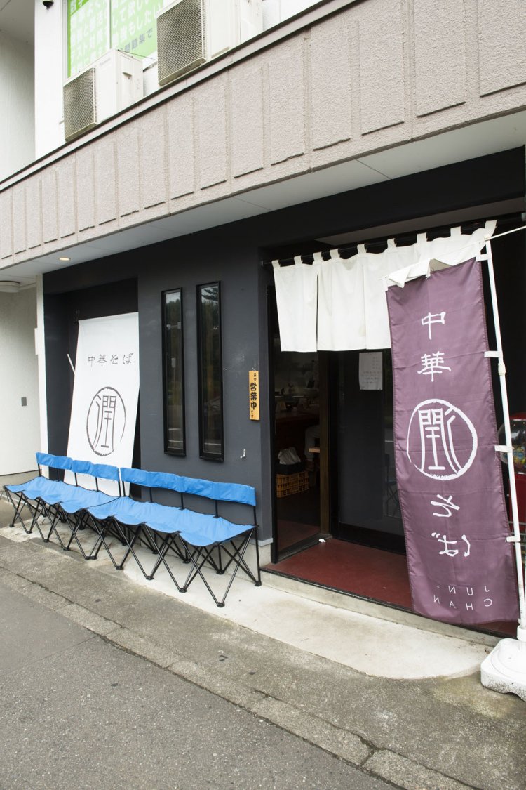 店長の名前の「潤」が書かれた紫ののぼりが目印。店内にはテーブル席もある。