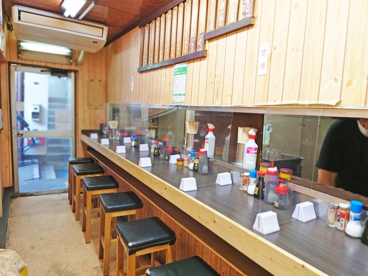 カウンター8席。狭い厨房で、ガッシリした体格の小澤さんが手際よくかつを揚げていく。