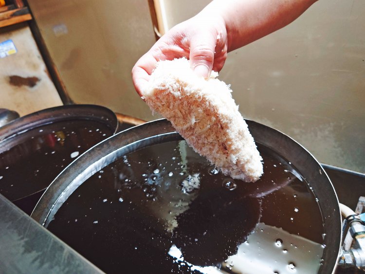 油に入れた瞬間に衣の花が咲く。こまめに揚げカスを取り除きつつ、低温でじっくり加熱。