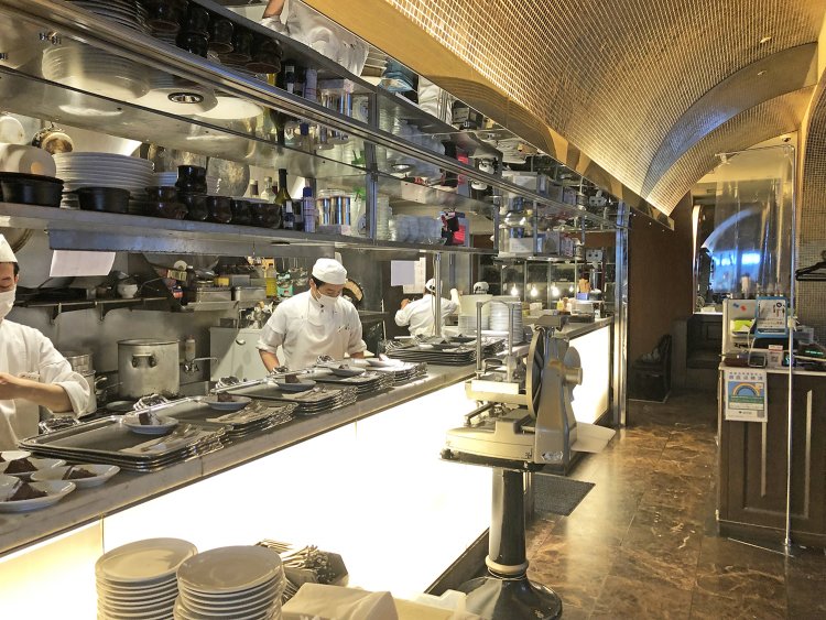 広々とした厨房で多くの料理人が働いている。