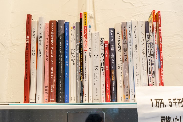 券売機の上に並ぶ書籍は、ラーメンからデザートまで。研究熱心さがうかがえる。