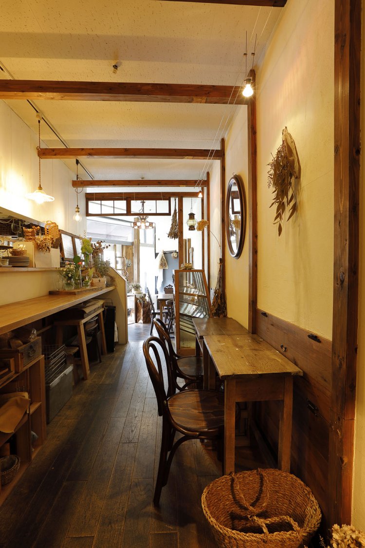 テーブルの一輪挿しや壁のドライフラワーのさりげないディスプレイも魅力的。