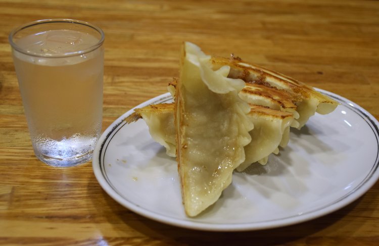 ギョウザはグラスとほぼ同じ高さ。ジャンボギョウザ4個とライス、スープ、もやしの和え物が付くギョウザライスは860円。