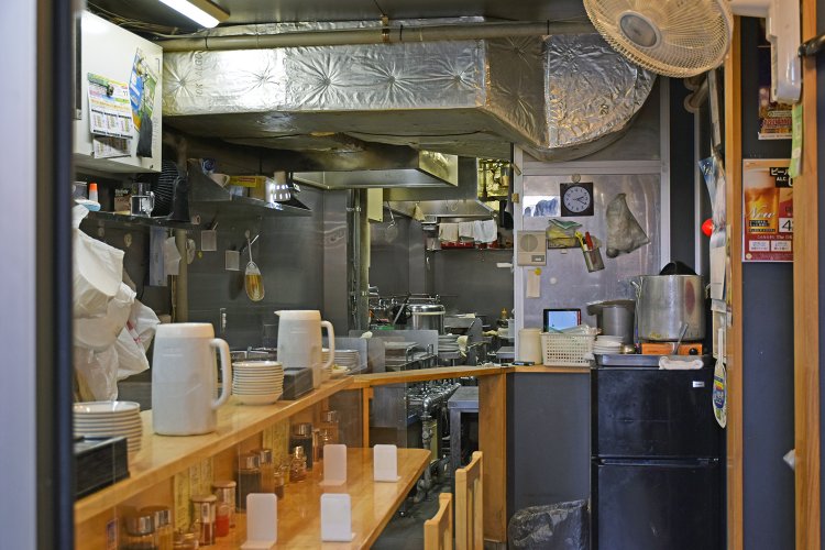 店内1階は厨房とカウンター席。カウンター席の背後に2階への階段がある。