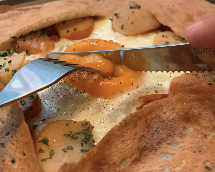 ガレットの醍醐味と言えばこれ！　卵の黄身を崩しながら食べるとまろやかな味わいに。