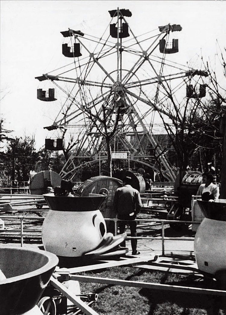 ［1950年ごろ］ 奥が初代の観覧車。ゴンドラが10個しかないところが愛らしい。手前はどこかで見たことのありそうなアヒル の回転遊具。