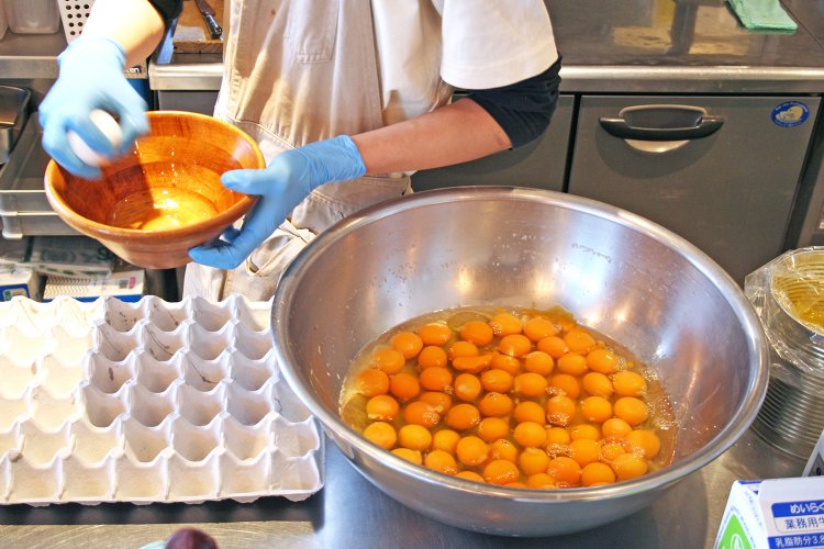 片手で卵を割り続ける姿はもはや職人技。平日は1日で約700個、週末は1日約900個の卵を消費する。