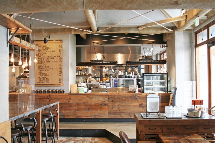 ドリンクはカウンターで受けとり、料理は席に運んでくれるシステム。カウンター内は広いオープンキッチンになっている。