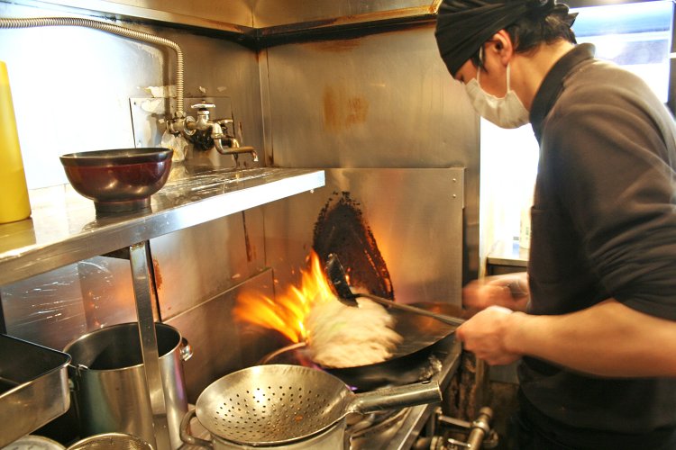 豪快に豚肉を炒める内田さん。