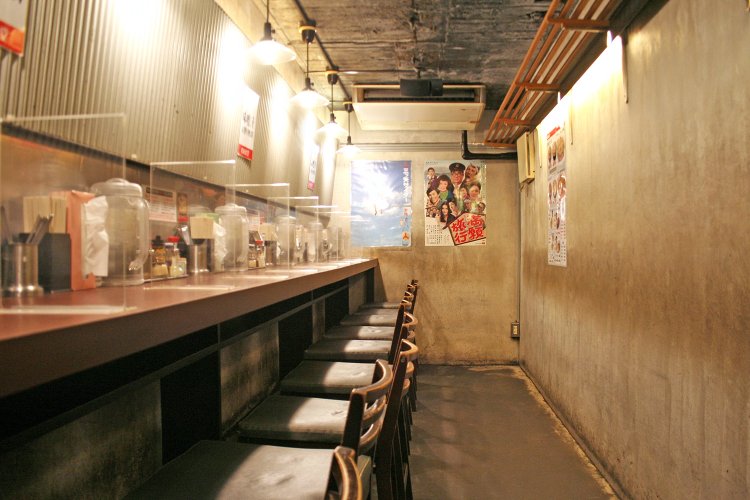 細長い中2階のフロアはカウンター席が9席。殺風景な壁と照明が逆におしゃれな感じ。