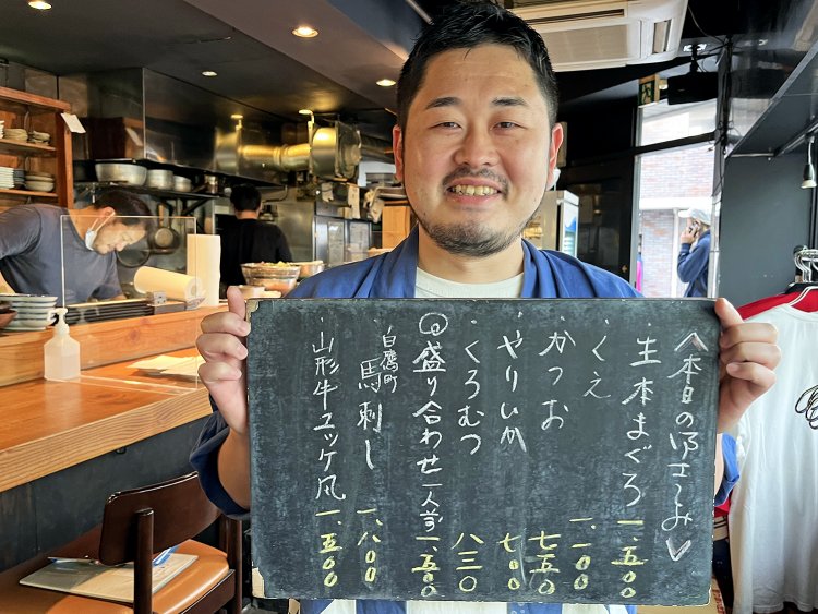 「日替わりの刺し身などは黒板を参照にしてください」。愛らしい笑顔の店長　笹谷健悟さん。