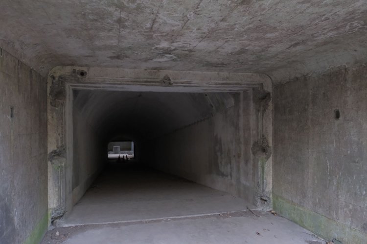 いざ入坑？　天井は普通くらいの高さだ。闇の先に見えるものは……。