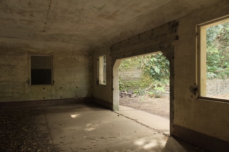 中心部の部屋は広い。先ほどの立入禁止の通路は「コ」の字にこの部屋を囲んでいる。奥の窓が気になるが、窓の向こうは通路だ。ここは資材置き場だったのか、隊員の待機施設だったのか。