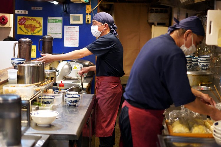 厨房に立つ店主の小林さん(左）