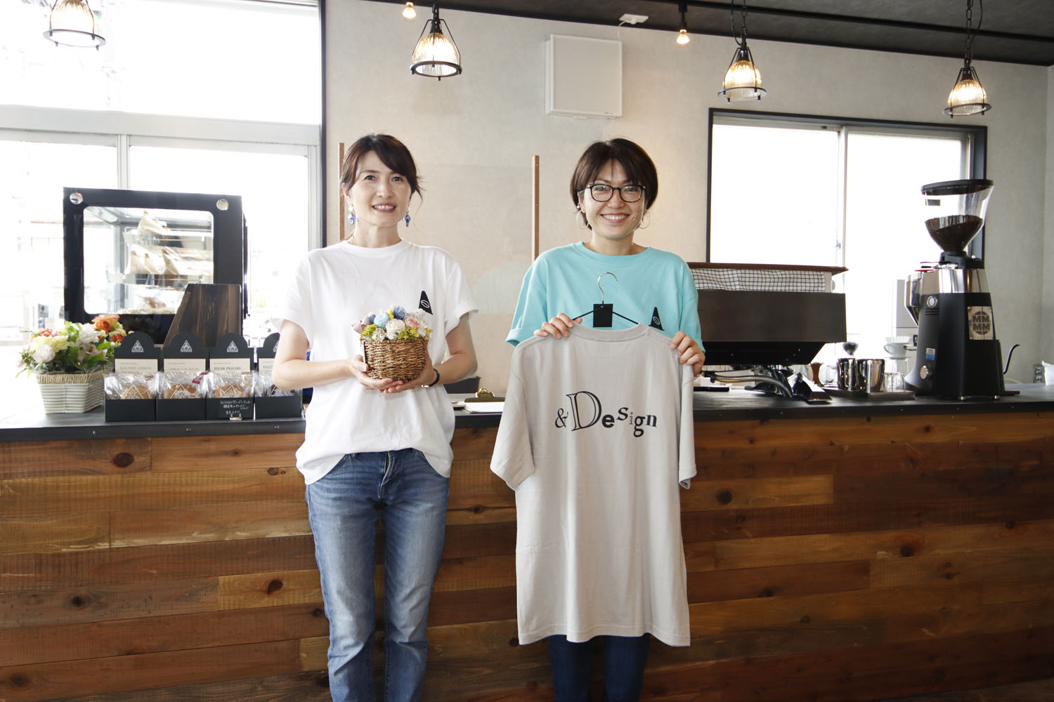 左から山本さんと冨田さん。ふたりは前職が一緒だった。オリジナルデザインTシャツ3000円や雑貨も販売中。