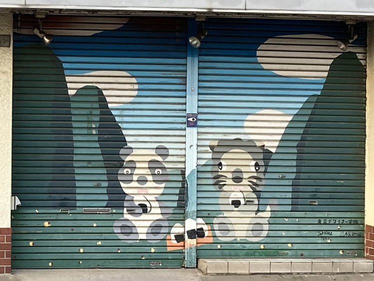 調布の薬局のシャッター。右下にサインが見える。