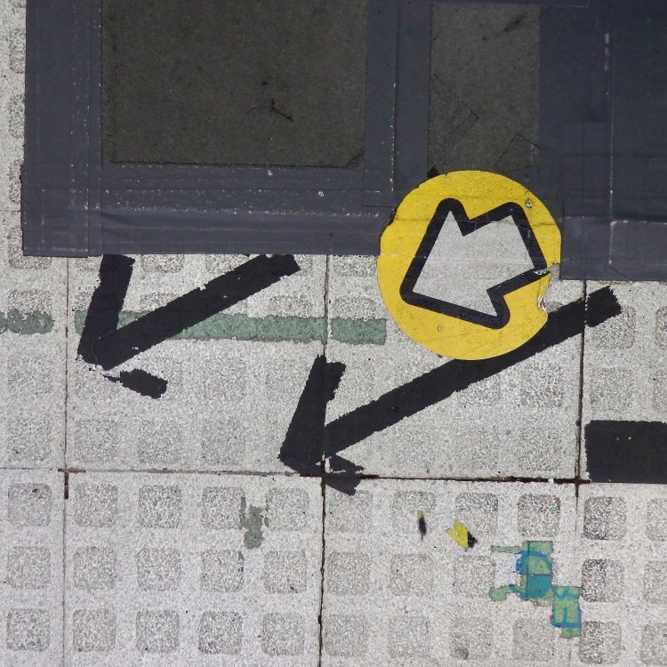 黄色地に白い公式矢印と並ぶ、テープの矢印。