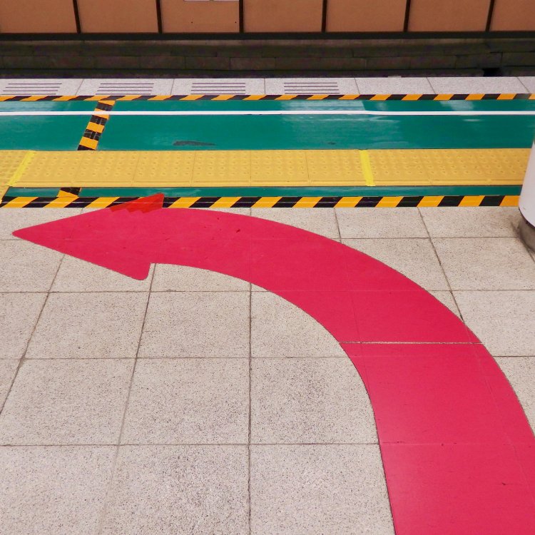 大きく力強い矢印が目を引く。グリーンのシートと黄色い点字ブロックとの色の組み合わせもキュート！