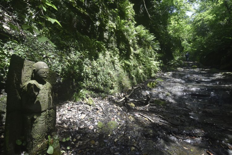 途中には石仏も。その前の道は水が流れていた。