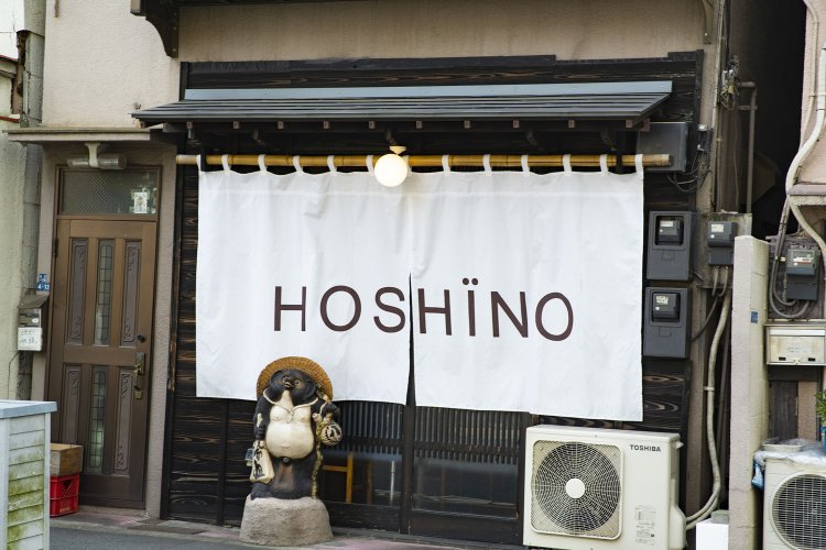 白い暖簾が目印。信楽焼の狸は寿司店時代からのもので、お客も幸運も呼ぶ縁起物だとか。