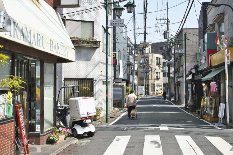 昭和7年（1932）に暗渠化されて道路に。現在は31店舗が営業。法明寺の御会式には一同熱が入る。