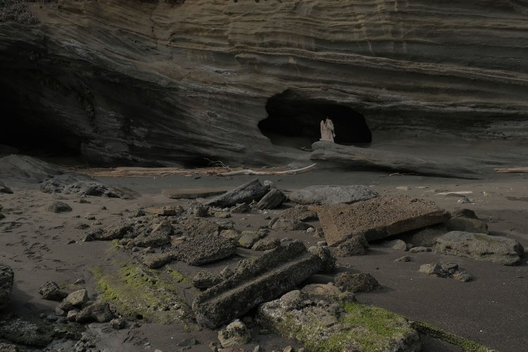 コンクリート片は岩と見間違えるほどだが長細い形状は明らかに人工物。奥に人がいるところが回天の格納用洞窟だったという。