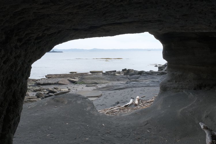洞窟から東京湾を見る。海岸には台座のコンクリートが散乱している。