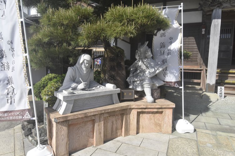 本堂前にある義経と、腰越状を認める弁慶主従の像。