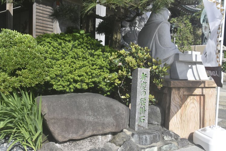 像の後ろには弁慶の腰掛石が置かれていた。