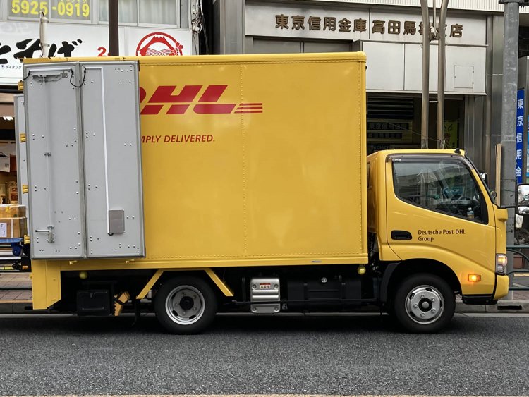 物流会社のトラック。全体がイメージカラーの黄色に塗られている。