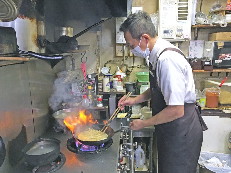 厨房でナポリタンを調理する勝村店長。リズムよく振るフライパンが王道ナポリタンの証。