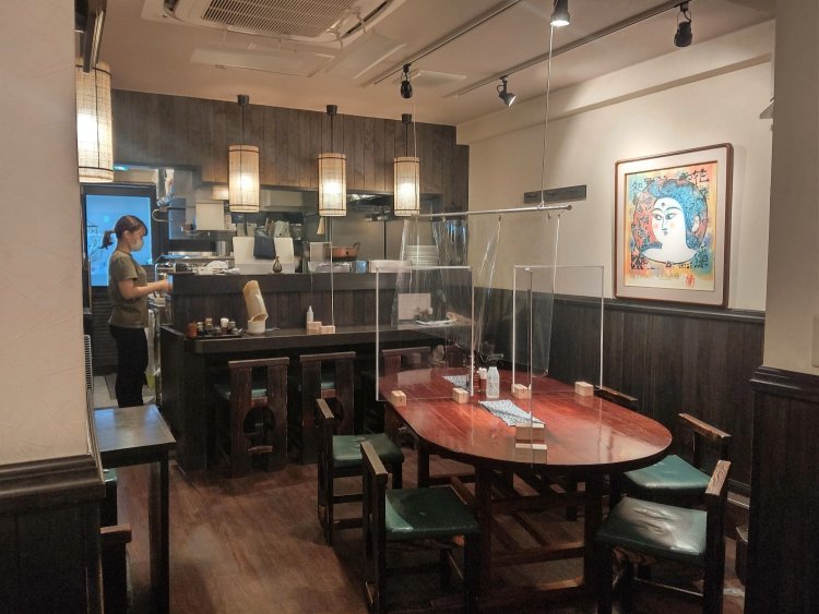 店内はカウンター4席、2つのテーブルを合わせて7席。壁には孝仁さんの出身地である青森の著名な版画家・棟方志功の作品やねぶた絵も。