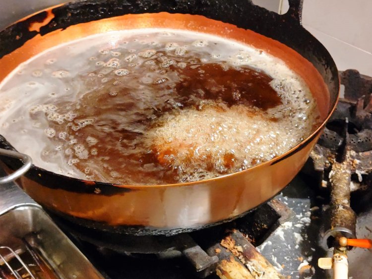 熱伝導性、蓄熱性ともに優れた銅鍋で揚げていく。肉の水分によって揚がり方も異なるという。