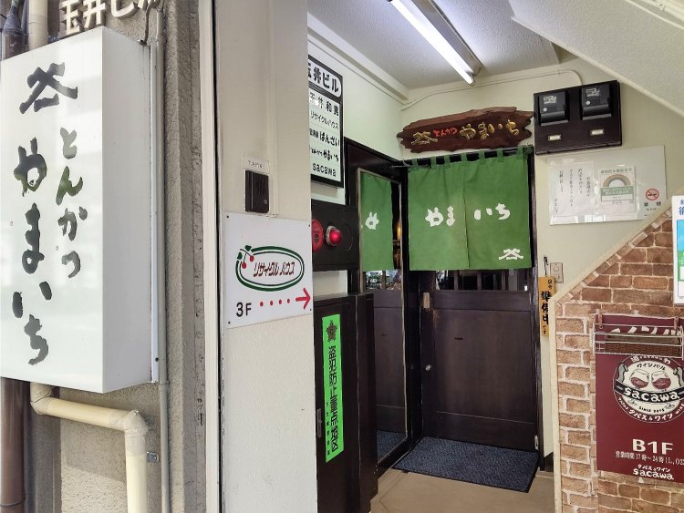 ビルには複数のテナントが入るが正面にかかる『やまいち』ののれんが目印だ。