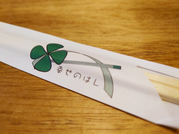 箸袋にも箸と四つ葉のクローバーが大きな懸け橋のように描かれた店名のロゴ。