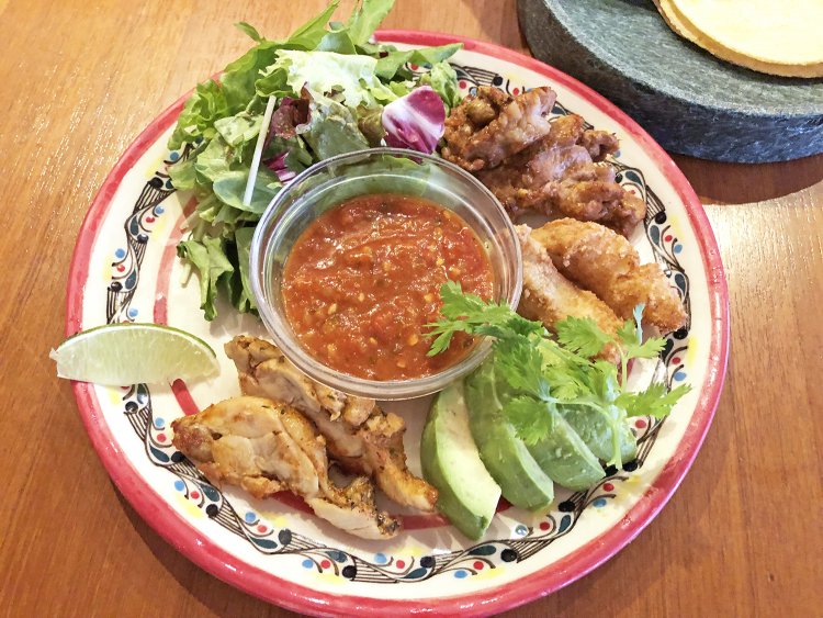 こだわりのトルティーヤにお皿が見えないほど具材が乗ったタコスプレート1100円。