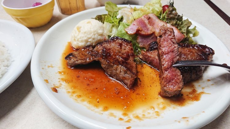 弾力ある肉はジューシーで、食べ応えの厚さ。すりおろし玉ねぎが入った醤油ベースのソースをたっぷり絡ませ、ご飯とほおばる。シアワセすぎる～。