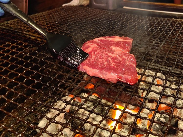 炭の近くに移し焼いていく。はけで塗っているのは肉の表面の乾燥を防ぐためのオリーブオイル。