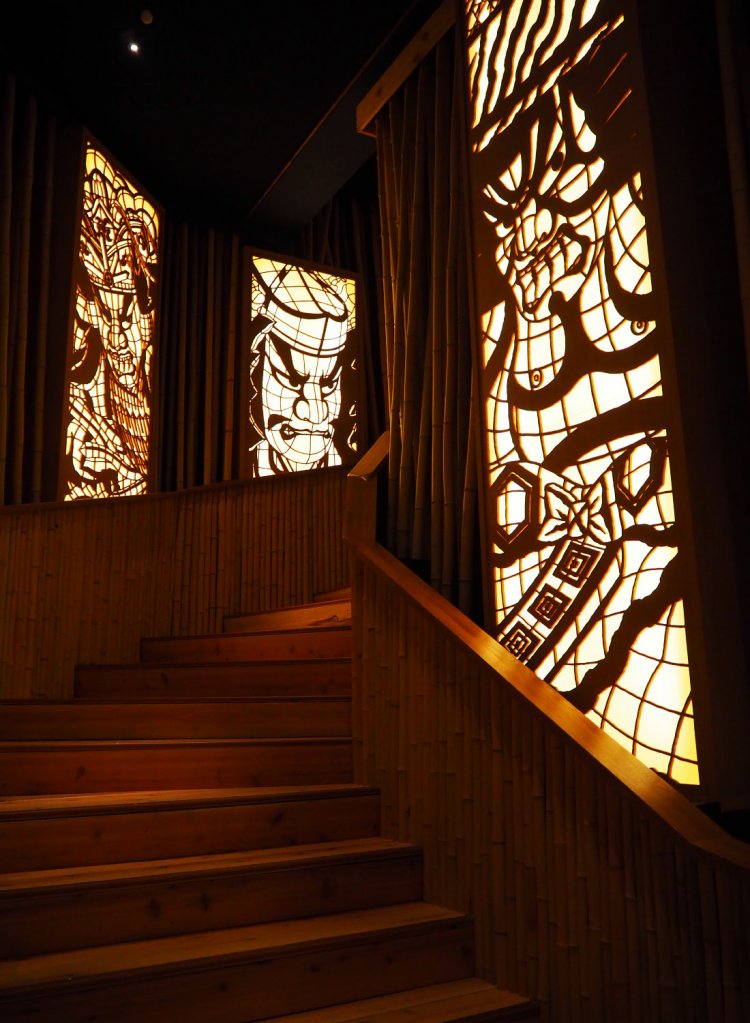 通路の両脇に、ねぶた師の立田龍宝（たつたりゅうほう）氏がデザインを担当した木製の切り絵が並ぶ。