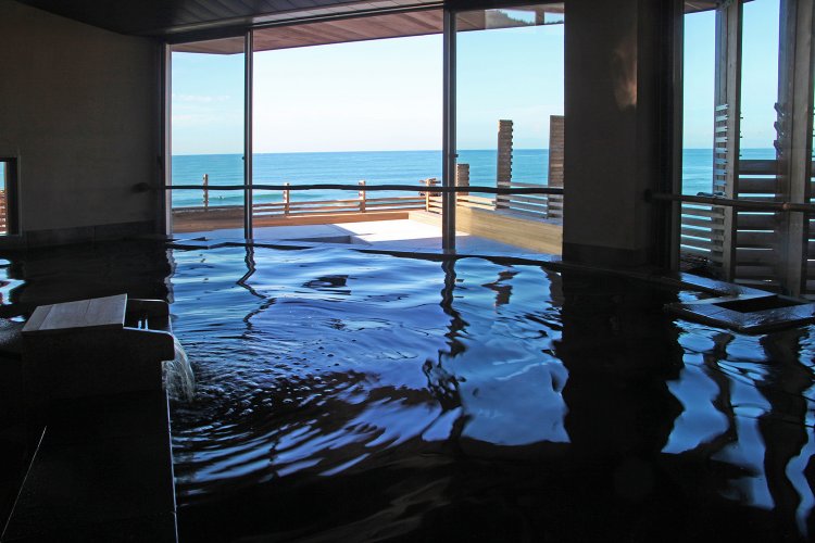 海が見渡せる内湯。大きな窓から入る風も心地いい。